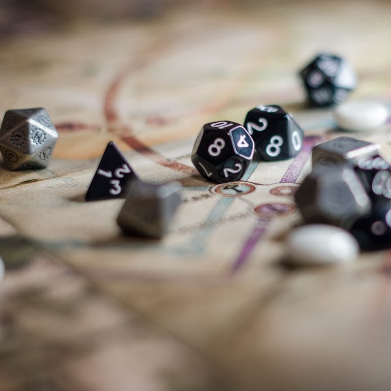 Black and metallic dice on a detailed board game map, perfect for RPG fans.